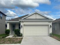 Charming single-story home with a two-car garage and well-maintained landscaping in a suburban neighborhood at 1556 N River Cir, Tarpon Springs, FL 34689