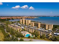 Beautiful aerial view of the condo buildings, pool, and surrounding waterfront on a sunny day at 2617 Cove Cay Dr # 710, Clearwater, FL 33760