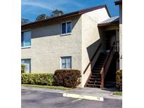 Beige two-story condo building featuring well-maintained landscaping at 4215 E Bay Dr # 1702F, Clearwater, FL 33764