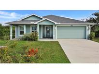 Charming one-story home featuring light green paint, a two-car garage, and a well-manicured front yard at 470 Sunset N Rd, Rotonda West, FL 33947