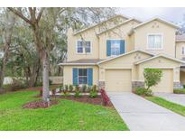 Charming two-story townhome with a well-manicured lawn and attached one-car garage at 10906 Kensington Park Ave, Riverview, FL 33578