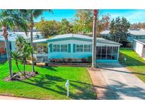 Charming home with a well-manicured lawn, lush landscaping, and a welcoming screened-in porch at 292 Salem Ave # 4, Palm Harbor, FL 34684