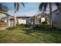 Charming single-story home with a well-maintained lawn, mature landscaping and inviting front porch with decorative wreath at 308 S Arrawana Ave, Tampa, FL 33609