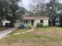 Charming bungalow with a red door, surrounded by lush greenery and stepping stone walkway at 314 33Rd N Ave, St Petersburg, FL 33704