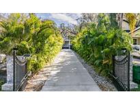 Long driveway lined with lush tropical foliage leading to a charming home at 6911 N 19Th St, Tampa, FL 33610