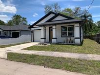 Charming single-story home with white siding, black trim, and a well-maintained lawn at 8111 N Edison Ave, Tampa, FL 33610