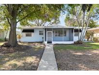 Charming single-story home featuring a screened porch, and a well-maintained front yard with mature trees at 930 40Th Ne Ave, St Petersburg, FL 33703