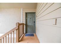 View of front door and porch area featuring wood railing and green door at 9481 Highland Oak Dr # 706, Tampa, FL 33647