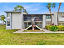 Inviting condo exterior with well-maintained landscaping and charming entrance staircase at 2073 Skimmer W Ct # 211, Clearwater, FL 33762