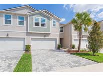 Charming townhome exterior with paver driveway and well-maintained landscaping in a vibrant community at 2334 Audubon Preserve Ln, Lutz, FL 33558