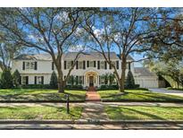 Stately white home framed by mature trees and lush landscaping. Brick walkway leads to the front entrance at 3412 W Mckay Ave, Tampa, FL 33609