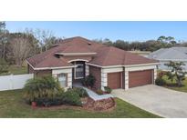 Stunning home featuring a well-manicured lawn, mature landscaping, and a two-car garage at 3613 Pendleton Way, Land O Lakes, FL 34639