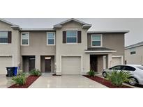 Attractive two-story townhome with attached garage, neutral colors, and manicured landscaping at 518 Glenn Cross Dr, Ruskin, FL 33570