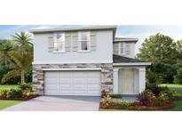 Charming two-story home with stone accents, a two-car garage, and lush landscaping at 5237 Salt Marsh Rd, Wimauma, FL 33598