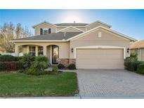 Charming two-story home featuring a manicured lawn and a two-car garage with beautiful stone accents at 19122 Sunset Bay Dr, Land O Lakes, FL 34638