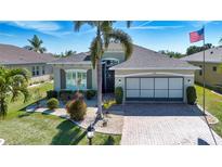 Beautiful single-story home with a well-manicured lawn, lush landscaping, and a brick paver driveway at 328 Siena Vista Pl, Sun City Center, FL 33573