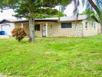 Charming single-story home featuring a stone facade, well-manicured lawn, and mature landscaping at 3453 Garfield Dr, Holiday, FL 34691