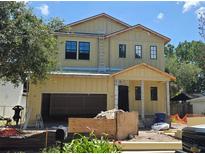 Exterior view of a two-story home under construction showing garage, door, and a ladder against the roof at 3618 W Royal Palm Cir, Tampa, FL 33629