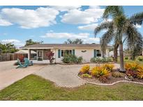Charming single-story home with a well-maintained yard, palm tree, and bright blue shutters at 829 E 4Th St, Englewood, FL 34223