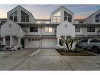 Charming townhome featuring a white exterior, attached garage, and well-maintained landscaping at 9770 Indian Key Trl # 102, Seminole, FL 33776