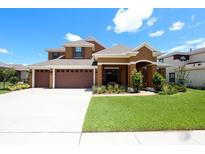 Beautiful two-story home featuring a three-car garage and manicured lawn at 15708 Oakleaf Run Dr, Lithia, FL 33547