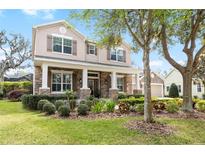 Stunning two-story home with a stone and tan facade, complemented by a meticulously landscaped front yard at 15912 Ternglade Dr, Lithia, FL 33547