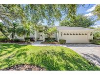 Charming single-story home with a well-manicured lawn, mature trees, and inviting curb appeal at 18806 Autumn Lake Blvd, Hudson, FL 34667