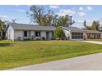 Charming single-story home with a well-maintained lawn and a two-car garage at 20191 Rutherford Ave, Port Charlotte, FL 33952