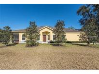 Charming one-story home with a well-manicured lawn and young trees lining the front at 6359 Timberly Ln, Zephyrhills, FL 33542