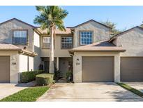 Charming townhouse featuring a well-maintained exterior, a private garage, and a mature palm tree at 720 Earls Ct, Safety Harbor, FL 34695