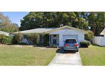 Charming single-story home with a well-manicured front lawn and attached garage at 1471 Gladys Cir, Dunedin, FL 34698