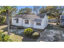 Charming single-story home with white exterior, well-maintained landscaping, and a concrete driveway at 2004 N Grady Ave, Tampa, FL 33607
