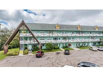 Three-story condo building with balconies, parking lot, and attractive architecture at 2042 Australia W Way # 66, Clearwater, FL 33763