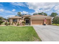 Charming single-story home featuring a two-car garage, landscaped front yard, and well-maintained lawn at 5088 Championship Cup Ln, Spring Hill, FL 34609