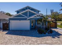 Charming two-story home featuring a lush landscaped yard, beautiful brick driveway, and a two-car garage at 5526 14Th S Ave, Gulfport, FL 33707