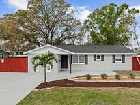 Charming single-story home featuring a gray exterior, well-manicured lawn, and a delightful palm tree in the front yard at 7480 Hobson Ne St, St Petersburg, FL 33702