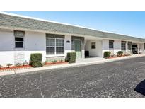 Charming single-story home with well-maintained landscaping, covered parking, and inviting green front door at 7825 38Th N Ter # 7825, St Petersburg, FL 33709