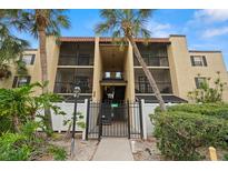 Condominium complex featuring gated entry, Spanish tile roof, and mature landscaping in a residential neighborhood at 107 S Obrien St # 217, Tampa, FL 33609