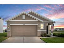 Charming single-story home featuring a two-car garage and a beautifully landscaped front yard at 10864 Penny Gale Loop, San Antonio, FL 33576