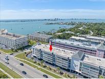 Stunning aerial view of a waterfront condominium complex with views of the bay and cityscape at 131 Bluff View Dr # 409, Belleair Bluffs, FL 33770
