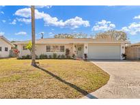 Charming single-story home with well-maintained lawn and inviting curb appeal on a sunny day at 1510 Lakeside Dr, Dunedin, FL 34698