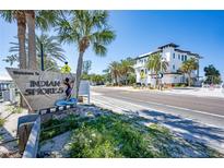 Indian Shores property with palm trees, welcome sign, and well-maintained landscape at 20256 Gulf Blvd, Indian Shores, FL 33785