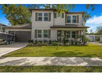 Charming two-story home with well-maintained lawn, shutters, and a boat in the driveway at 3012 W Leroy St, Tampa, FL 33607