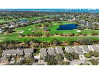 An aerial view shows the community's golf course, lake, and condo complex with lush green landscaping at 39 Pelican Pl, Belleair, FL 33756