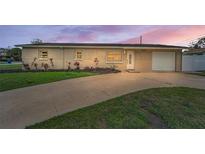 Charming single-story home with an attached garage, driveway, and manicured front lawn at 6310 57Th N Ave, St Petersburg, FL 33709