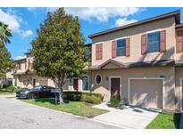Charming townhome showcasing a well-maintained exterior, manicured lawn, and convenient one-car garage at 10249 Villa Palazzo Ct, Tampa, FL 33615