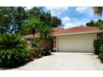Charming single-story home featuring a barrel tile roof, lush landscaping, and a well-maintained two-car garage at 4579 Del Sol S Blvd, Sarasota, FL 34243