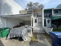 Modest two-story home with covered parking and a quaint front entrance at 5034 Terrace Village Ln, Tampa, FL 33617
