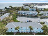 Aerial view of waterfront condos with boat slips, a community pool, and well-maintained landscaping near the bay at 5075 Starfish Se Dr # B, St Petersburg, FL 33705