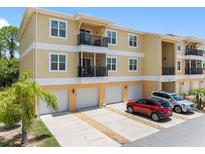 Spacious condo building featuring private garages, balconies, and manicured landscaping, enhancing curb appeal at 5089 Royal Palms Way # 202, New Port Richey, FL 34652
